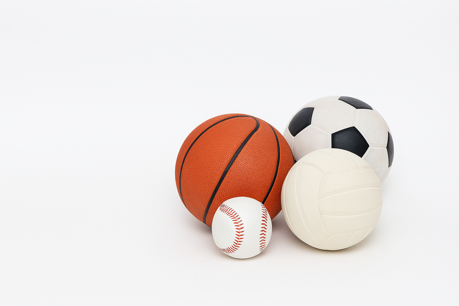 野球・バスケットボール・サッカー・バレーボールのボールが並ぶ画像。スポーツによるケガの予防と回復を支える木野内接骨院のイメージ。